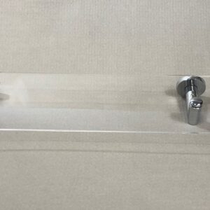 Repisa de metacrilato transparente Carena Brillo con soportes cromados, instalada en la pared de un baño
